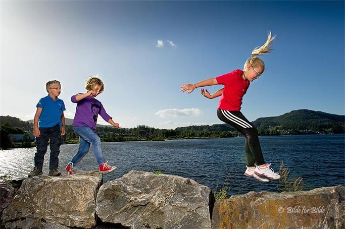 Barn som hopper på steiner - Klikk for stort bilde